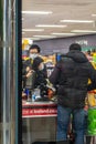 UXBRIDGE, LONDON/ENGLAND Ã¢â¬â MARCH 14 2020: Shoppers in surgical masks queueing a Iceland supermarket